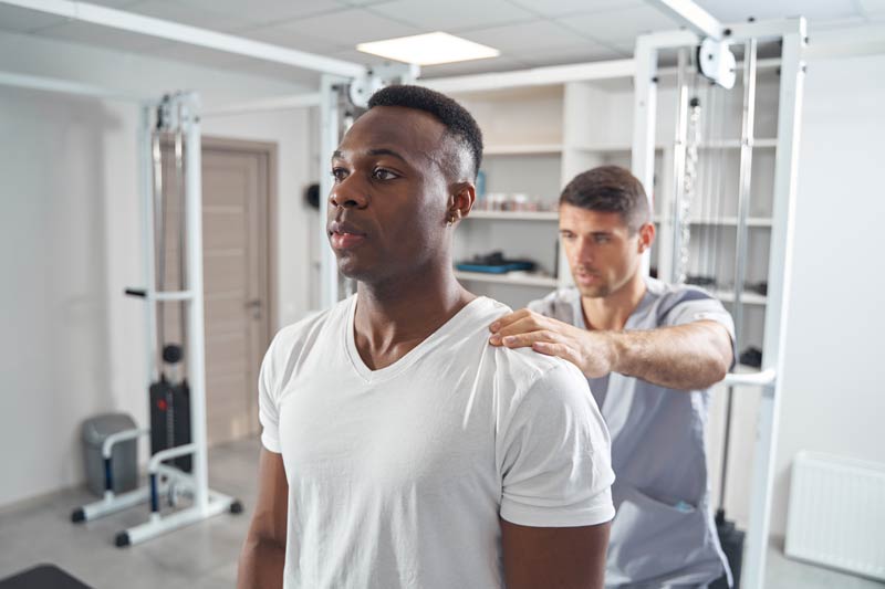 man undergoing physical exam of upper back