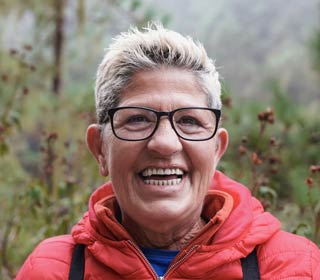 senior woman smiling on camera during trekking day