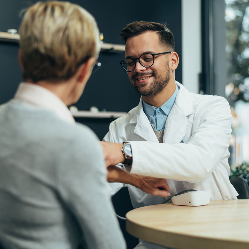 young smiling doctor checking senior woman patient